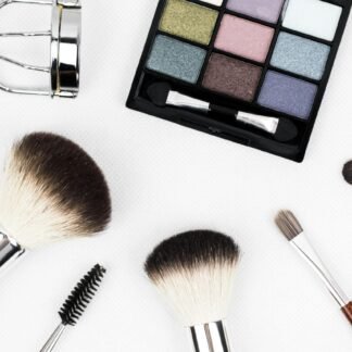 Top view of makeup tools and a colorful eyeshadow palette arranged artistically.